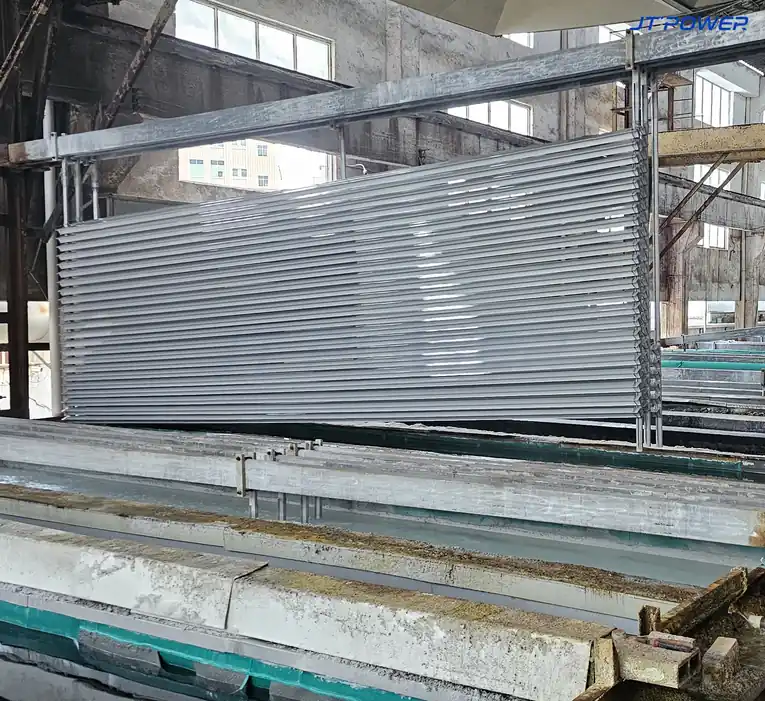 铝电解抛光与氧化产线上，装满铝型材的挂具吊在槽体上方